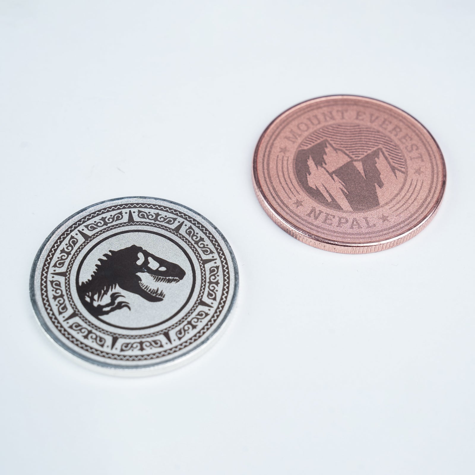 Two Creality Falcon 3-Color Blank Commemorative Coins for Laser Engraver (6pcs) are shown on a white surface: one silver with a dinosaur skull design, and one copper featuring mountains and "Mount Everest Nepal" text. Two Creality Falcon 3-Color Blank Commemorative Coins for Laser Engraver (6pcs) are shown on a white surface: one silver with a dinosaur skull design, and one copper featuring mountains and "Mount Everest Nepal" text.
