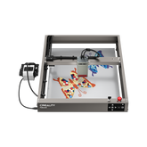 A Creality Falcon Falcon2 40W Diode Laser Engraver with an anodized aluminum alloy frame engraves colorful butterfly designs on a flat surface, its head positioned above the artwork.