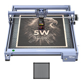 The 5W CR-Laser Falcon Engraver and Cutter by Creality Falcon demonstrates its precise engraving by etching a detailed eagle and “5W Falcon” on wood, using a removable honeycomb panel for versatile materials.