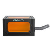 The black Creality Falcon Protection Enclosure Pro for Falcon Laser Engravers features smokeproof, dustproof design, a large orange-tinted dual-view window, visible side vent with flexible gray hose, and an illuminated CREALITY logo on the front.
