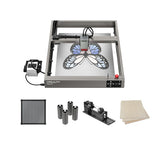 The Creality Falcon Falcon2 22W Diode Laser Engraver creates colorful butterfly engravings on metal plates and comes with a laser module, rotary attachment, filter, three metal cylinders, and two wooden boards for engraving.