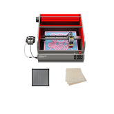 The Creality Falcon Falcon2 Pro 22W Enclosed Laser Engraver and Cutter Bundle, featuring a red enclosure, intricate designs on a black grid panel and two light-colored wooden sheets, offers visual assistance for precision in wood engraving.