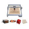 The Creality Falcon CR 5W Diode Laser Engraver showcases ultra-fine engraving on a wooden sheet with intricate patterns, displayed alongside orange safety glasses, a laser module, a red storage box, and extra wood sheets.