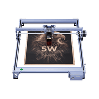 The Creality Falcon CR 5W Diode Laser Engraver etches an eagle image with "5W FALCON" onto wood. Its metallic frame ensures ultra-fine engraving precision, delivering impressive detail.
