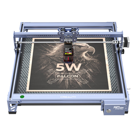 The Creality Falcon 5W CR-Laser Falcon Engraver and Cutter, featuring advanced design and ultra-fine precision, engraves an eagle and "5W FALCON" onto a square wooden board within its blue metal frame marked "CREALITY.