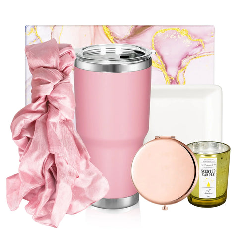 The Car Water Cup DIY Women's Gift Set for Laser Engraving by Creality Falcon—a delightful ensemble featuring a pink tumbler, pink silk scrunchie, green scented candle, and rose gold makeup mirror—is beautifully arranged with a marble-style pink and gold notebook, creating an ideal anniversary gift for her.