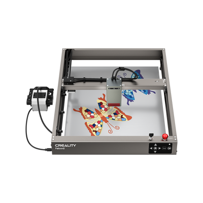 A Creality Falcon Falcon2 40W Diode Laser Engraver with an anodized aluminum alloy frame engraves colorful butterfly designs on a flat surface, its head positioned above the artwork.