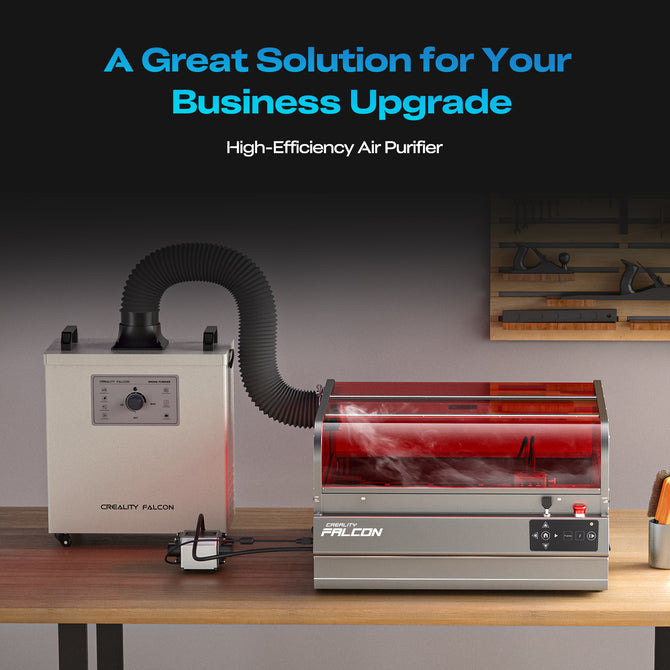 A Creality Falcon Falcon2 Pro S 40W Enclosed Diode Laser Engraver sits on a wooden table with tools hanging on the wall behind it. A desktop air purifier, in red and silver, is beside it. Text above advertises a business upgrade solution.