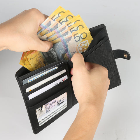 A person is holding an engraved leather wallet by Creality Falcon, removing several Australian fifty-dollar notes. The wallet, ideal for vaccine cards, also holds a credit card and driver's license.