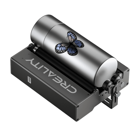 The Creality Falcon Rotary Roller for Laser Engraving Machine, featuring adjustable width, is engraving a blue and black butterfly design onto a cylindrical metal tumbler, suitable for tumblers or bottles of various diameters.