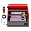A Creality Falcon Falcon2 Pro 60W Enclosed Laser Cutter and Engraver is seen adjusting its cutting power. The laser arm engraves a detailed pattern on a blue surface under the red safety cover, with its control panel and wiring visible on the left of this advanced machine.